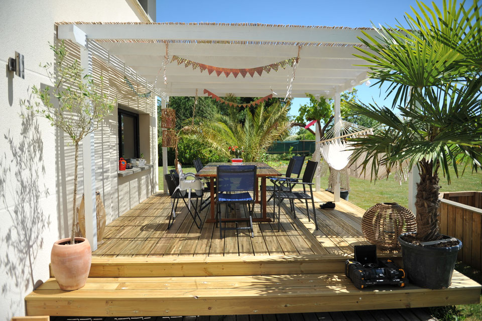 Terrasse bois avec pergola blanche et voile d'ombrage