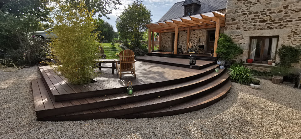 Grande terrasse bois exotique avec marches courbes et pergola